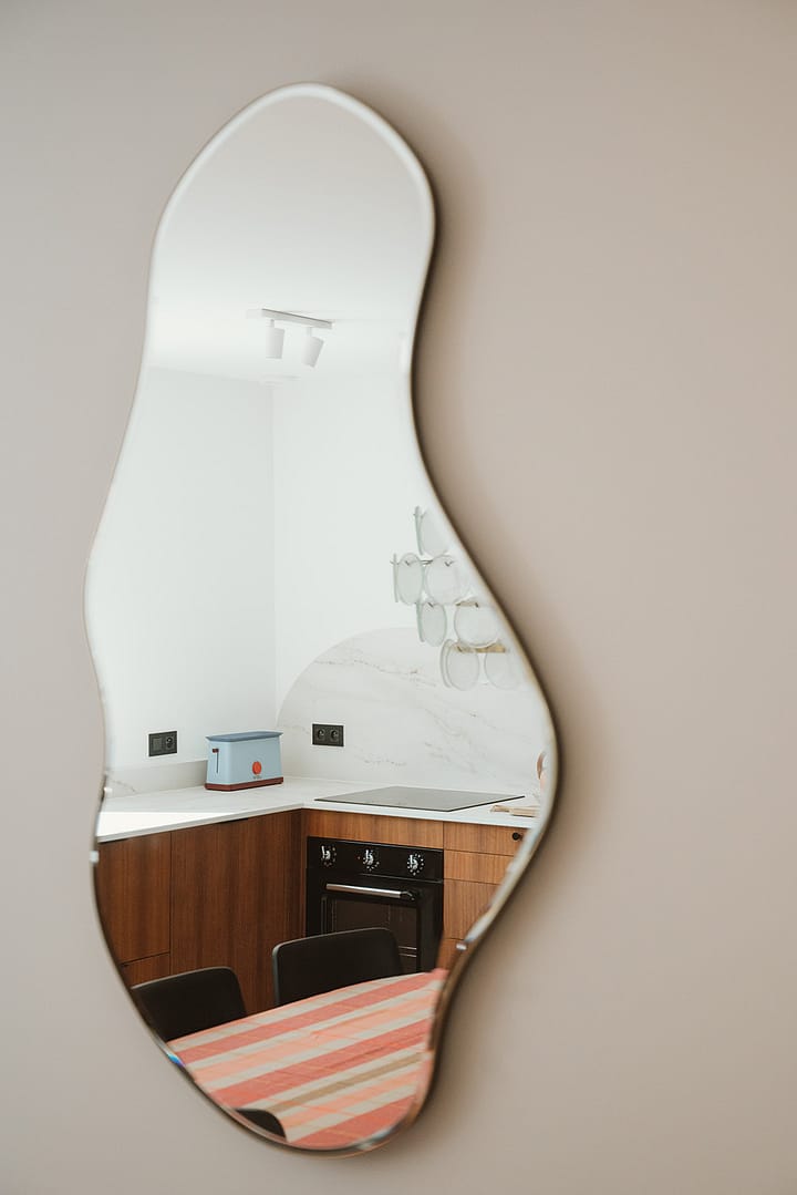 noesis-cuisine-bois-lumineux-salon-cheminée-canapé-osier-miroir-courbe